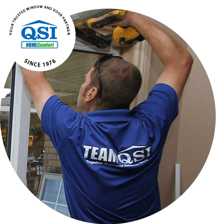 A QSI window installer drills in the final touches on a replacement window.
